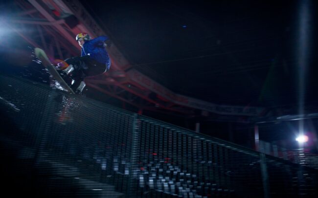Snowboarder Clemens Millauer doing a trick in the Red Bull Arena Salzburg