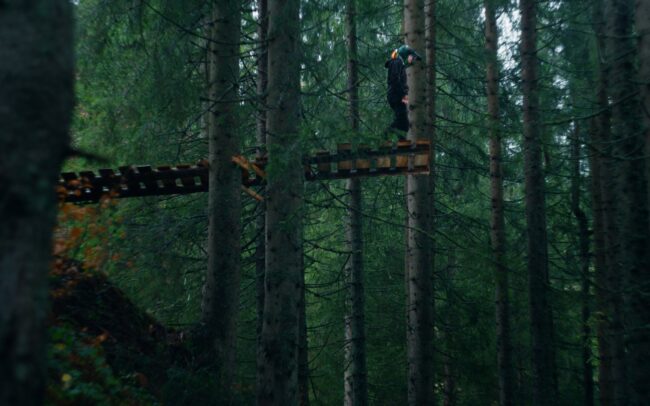 Stevie Schneider standing on top of a huge self-built North Shore. It doesn't look safe.