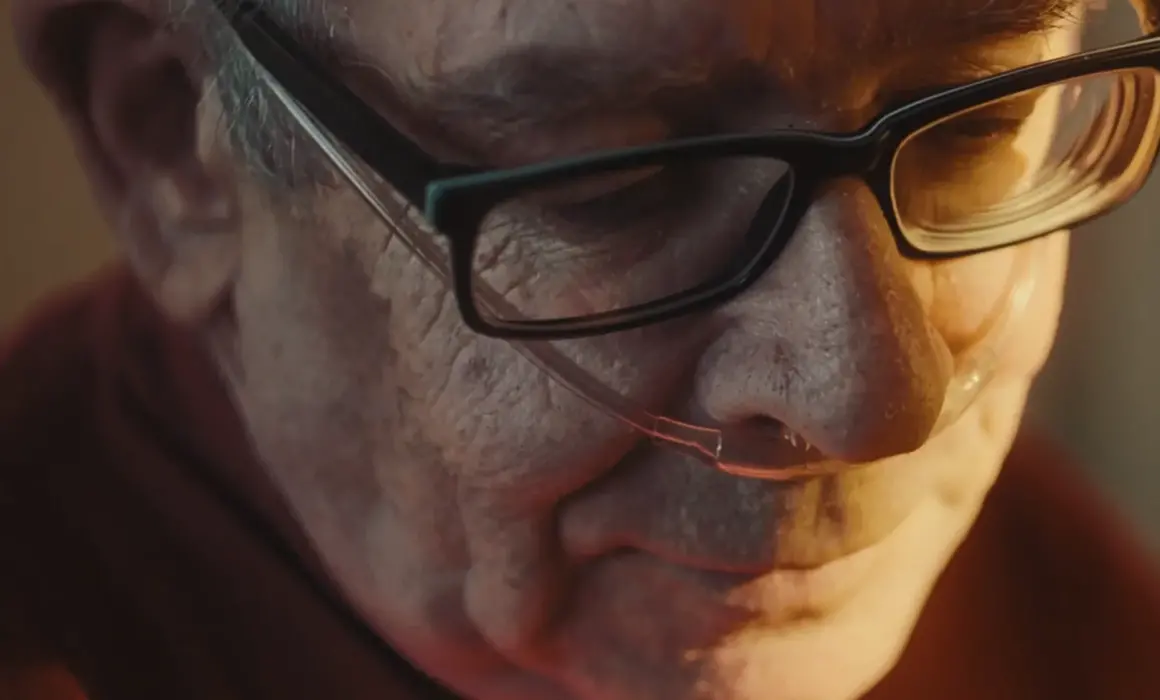 Still from Zukunft Pflege showing an old man sitting in a ray of sunlight.