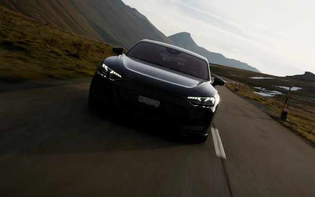 Hero shot of an AUDI RS e-tron GT driving through the Swiss Alps in the morning.
