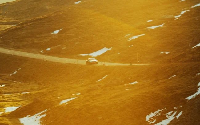 An AUDI RS e-tron GT driving in the golden morning light in the Swiss Alps.