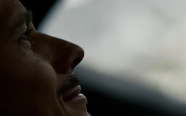 Closeup of a smiling man driving an AUDI RS e-tron GT.