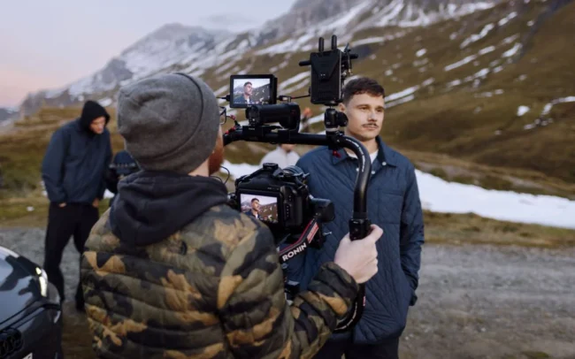 Director of Photography Imanuel Thallinger filming a shot of the talent with a gimbal in the Swiss Alps. Photo by Patrick Güller.