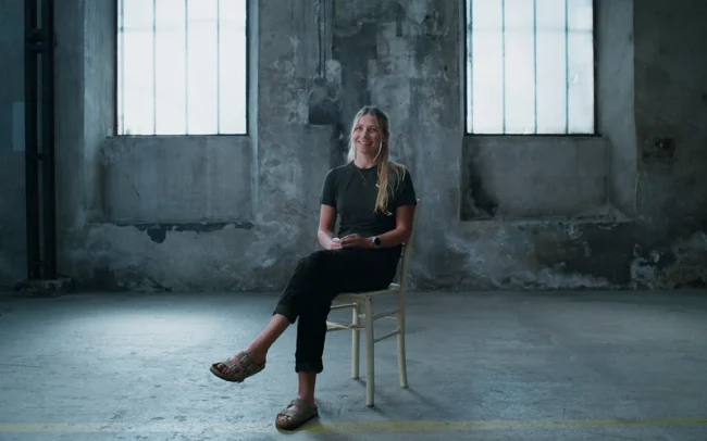 Elisa Deutschmann sitting in an old dirty factory for her interview in A Journey 2 Mont Blanc.