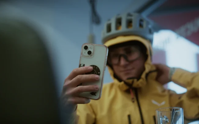 Magdalena Mittersteiner checking her yellow bike outfit in her phone's front camera.