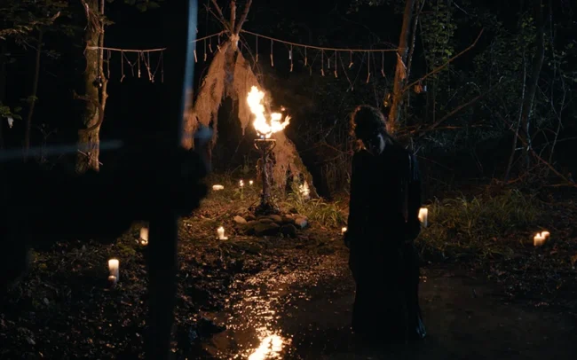 The witch is being threatened by a hunter with his arrow.