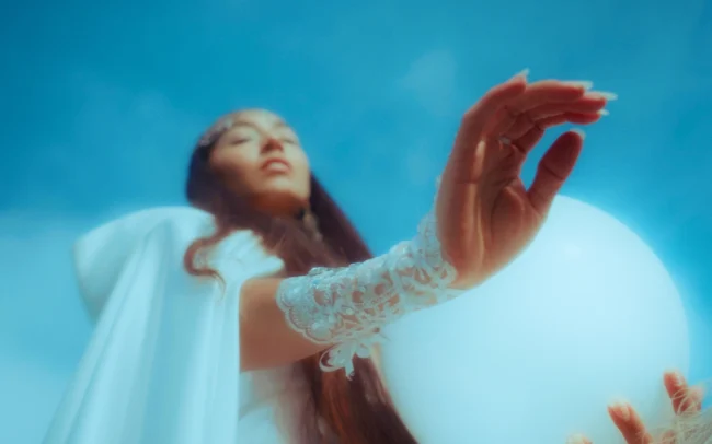 Gavriela holding a magic orb in her music video Tromba.