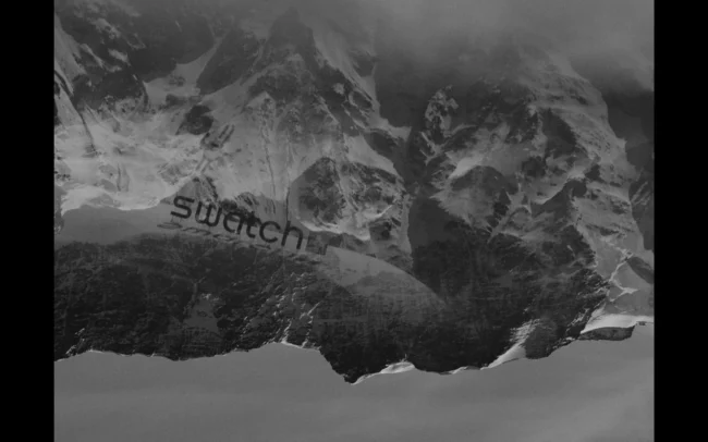Mountains reflecting in the lense showing a SWATCH logo.