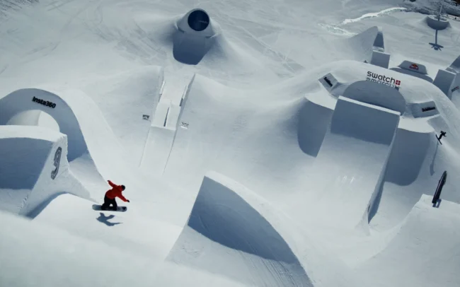 A snowboarder heading towards a giant kicker