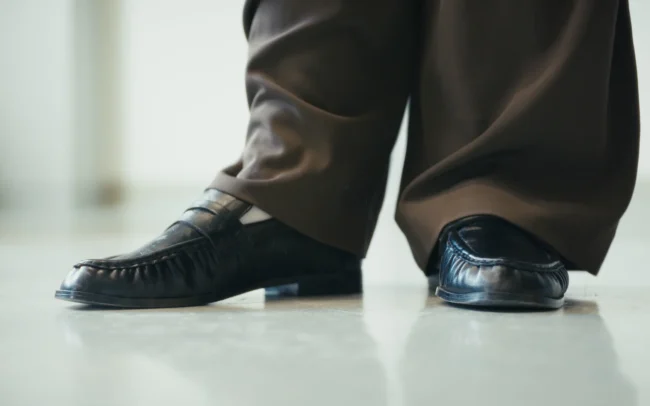 Artistic close-up shot of elegant shoes on a shiny floor framed by cinematographer Imanuel Thallinger.